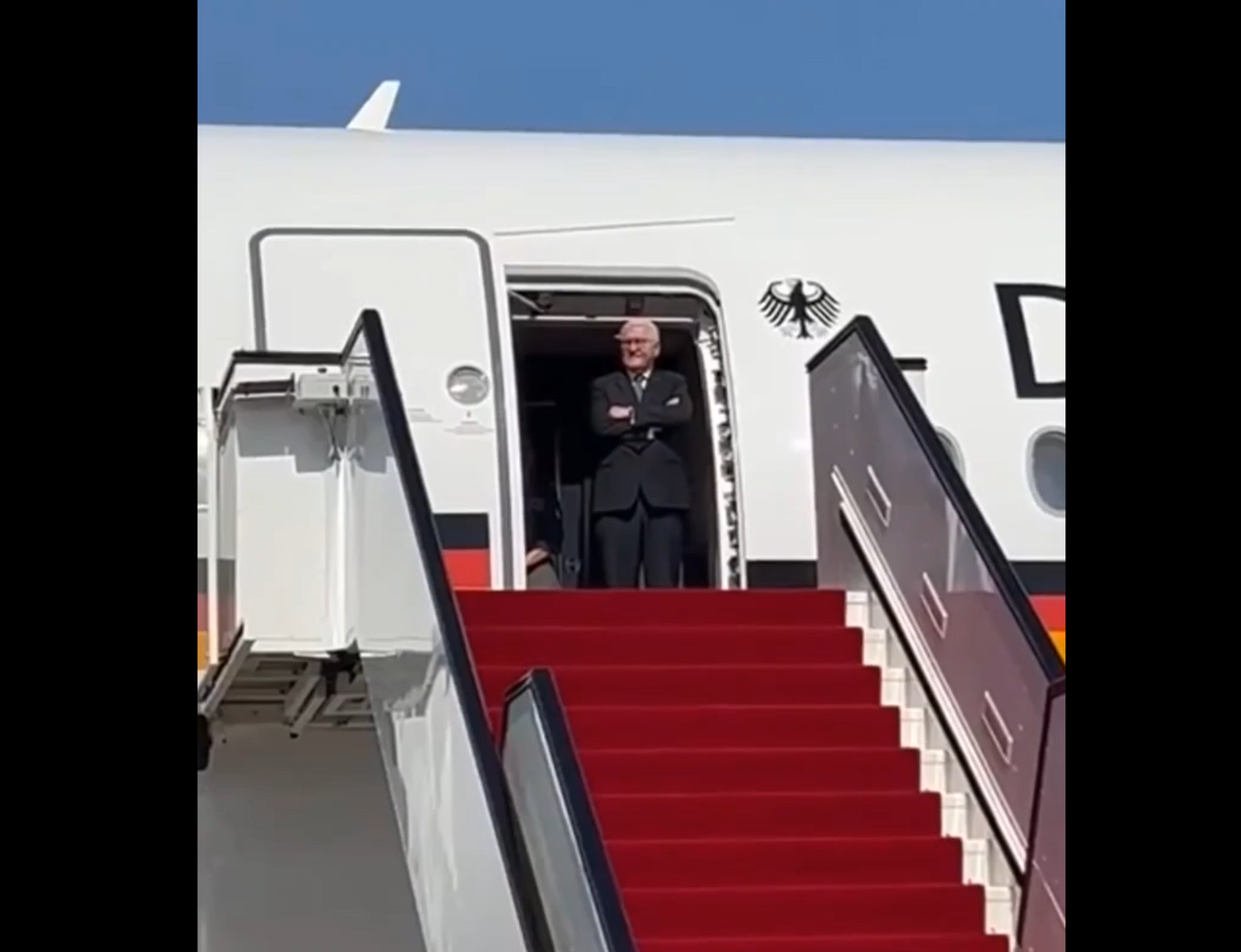 Германский президент Вальтер  Штайнмайер прибыл в Катар и пытается увидеть в "толпе встречающих" кого-то с табличкой со своим именем.