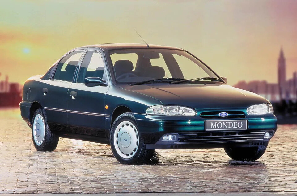 Форд Мондео (1993) Mondeo был первым европейским среднеразмерным автомобилем Ford с передним приводом. Выпущенный всего через 11 лет после Sierra, он казался чем-то из совершенно другой эпохи, не в последнюю очередь потому, что это был отличный автомобиль для водителя даже в самой простой форме.

Всего лишь третий Ford за три десятилетия, получивший награду «Автомобиль года» в Европе, он был доступен в кузовах седан, хэтчбек и универсал, а также с двигателями от 1,6-литрового четырехцилиндрового до 2,5-литрового V6. С меньшей линейкой двигателей и только одним типом кузова, тот же автомобиль позже был переработан для рынков Северной Америки, где он продавался как Ford Contour и Mercury Mystique.

