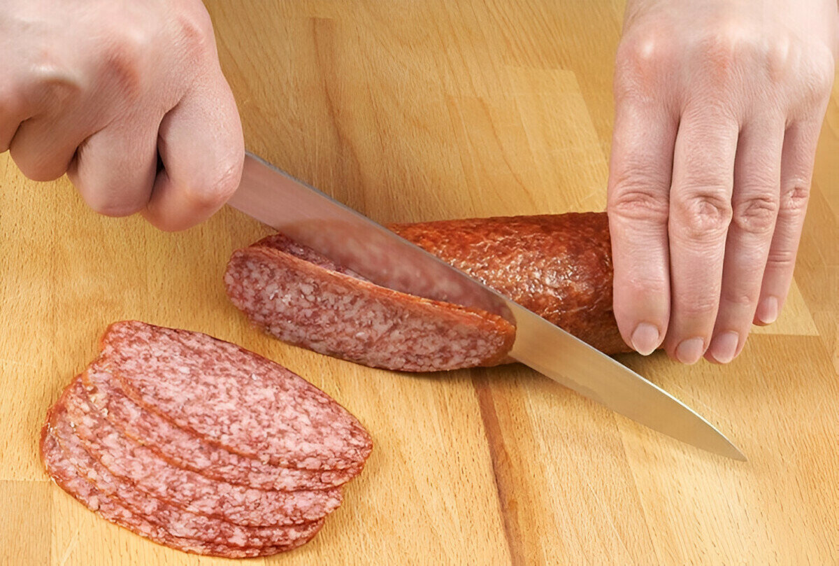 Есть мясо с ножа. Колбаса нарезанная. Порезанная колбаса. Нарезанные куски колбасы.