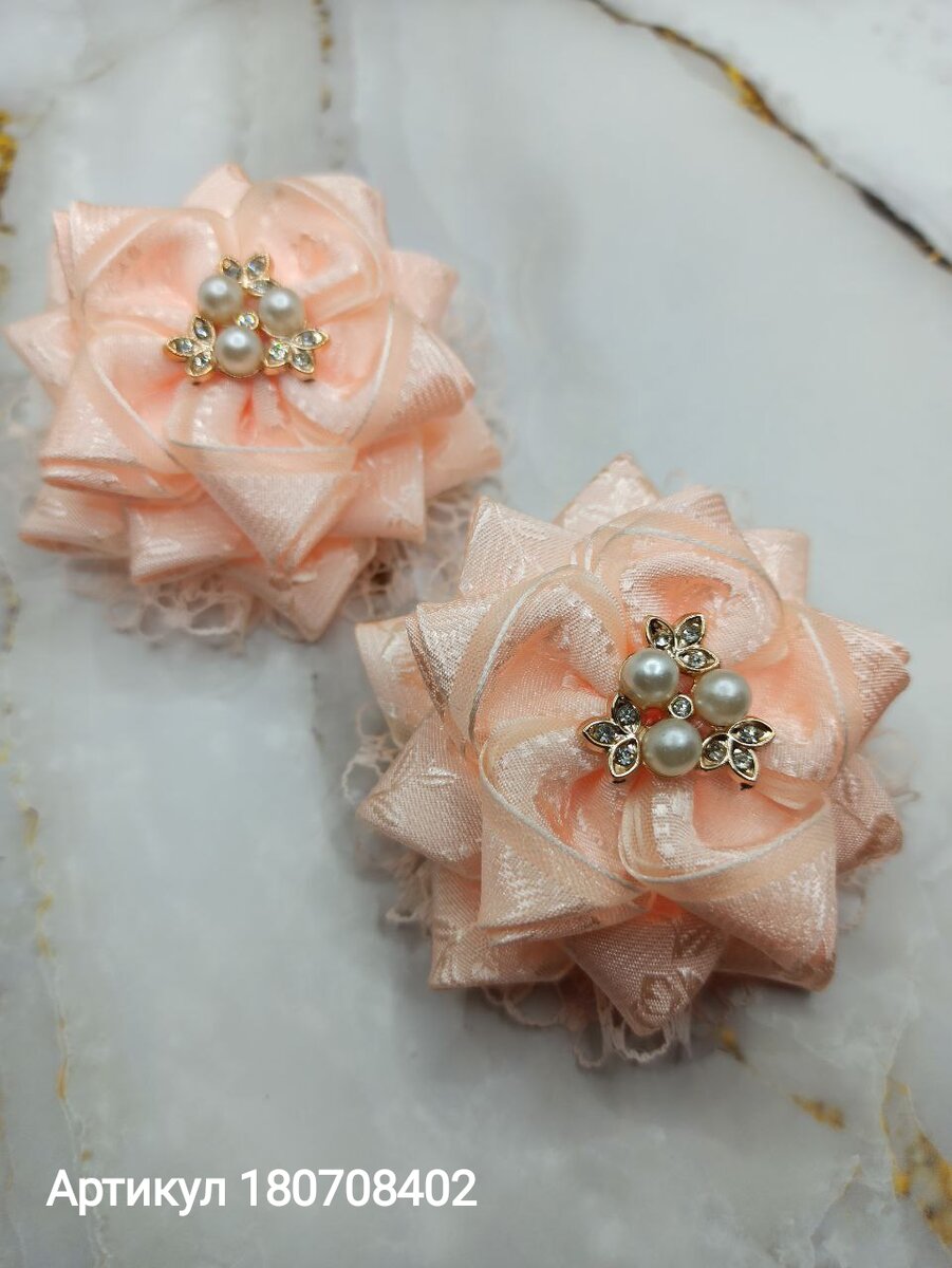 Банты выполнены из органзы персикового цвета, эти банты привлекают внимание своим нежным оттенком. Кроме того, каждый бантик декорирован ажурной лентой, которая придаёт им изысканный вид. Дополнительный акцент создают стразы, расположенные в центре банта. 
