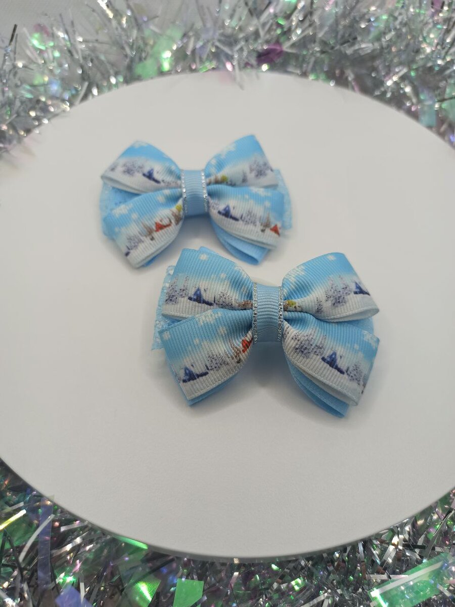 Комплект бантиков ручной работы станет прекрасным дополнением к праздничному образу и позволит создать неповторимый и стильный вид. Бантики выполнены из высококачественной репсовой ленты голубого цвета с новогодним рисунком, что придаёт им особую фееричность и праздничность. Ажурная лента также дополняет новогодний рисунок, создавая гармоничное цвета и текстуры. 