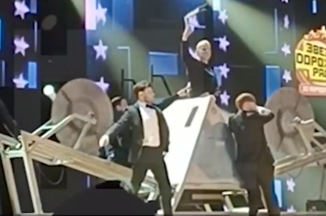    Певец забирается в ящик. Фото: Скриншот видео «5 канала»