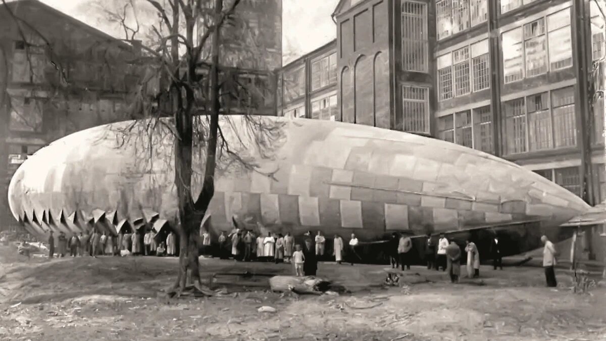 1924 год. Оболочка дирижабля «Московский химик-резинщик» (МХР) во дворе завода «Красный каучук». Это один из первых летательных аппаратов молодой Страны Советов, который с 1923 года строился на деньги, собранные рабочими резиновой и химической промышленности Москвы и ее области. В корме открытой гондолы был установлен двигатель Fiat мощностью 105 л.с., способный разгонять дирижабль до 62 км/ч и перевозить на борту до 900 кг. 16 июня 1925 года прошел первый полет корабля, продолжавшийся более двух часов. Поскольку дирижабль предназначался не только для агитационных полетов, но и для воздушной разведки, его оболочка имела камуфляжную раскраску. При перелете из Ленинграда в Москву дирижабль был по ошибке обстрелян караулом военного завода, что привело к вынужденной посадке недалеко от Твери

Фото: Денис Токмаков