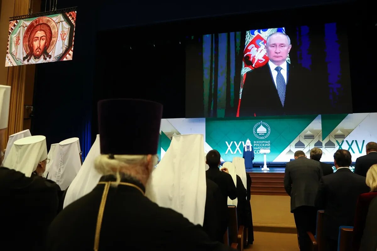 Патриарх Кирилл (на сцене) и президент РФ Владимир Путин (на экране) во время пленарного заседания XXV Всемирного Русского народного собора в Государственном Кремлевском дворце. Фото: Сергей Карпухин / ТАСС 
