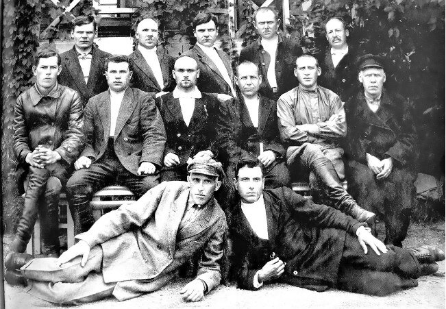 На фото стоят (слева-направо): Е.Е. Максимов, И.М Пневский, И. Калинкин, И.Л. Шадрин,  С.Г. Вологодский (врач). Сидят: Е.П. Максимов, С.Ф. Белоконь, Я.И. Иванов, А.И. Попов, И.М. Парамонов, Рычков. Лежат: Петров, Т.П. Толстоногов, командир 4-го батальона Северо-Ачинского полка. 1920-1930 гг.