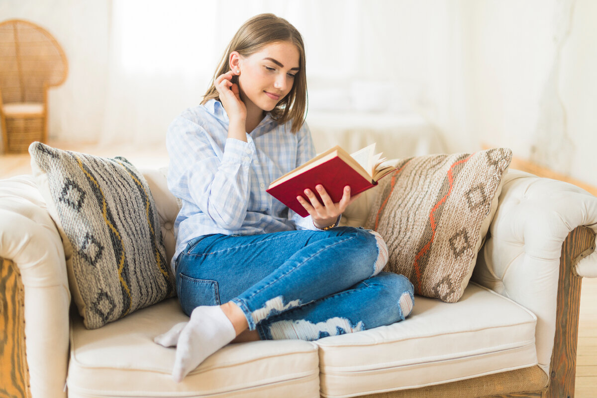 Is she in the living room. Диван для чтения. Женщина читает. Женщина читает на диване. Девушка читает книгу на диване.