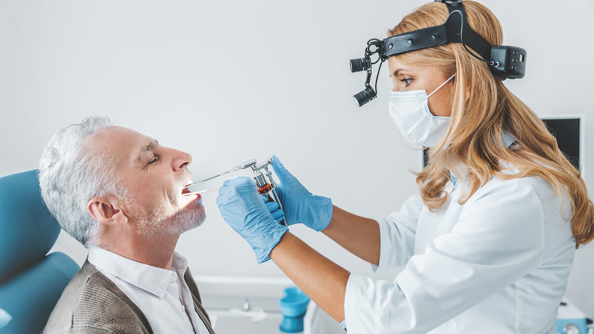 Врач-фониатр проводит осмотр гортани 