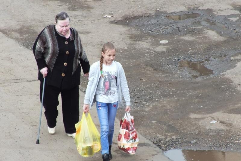 Девочка помогает донести тяжелые сумки
