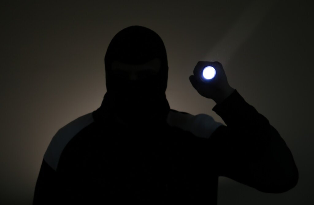 Criminal man. Flashlight man. Рука держит фонарик. Человек держит фонарик направленный на свое лицо. Человек держит фонарик в чёрной кофте.