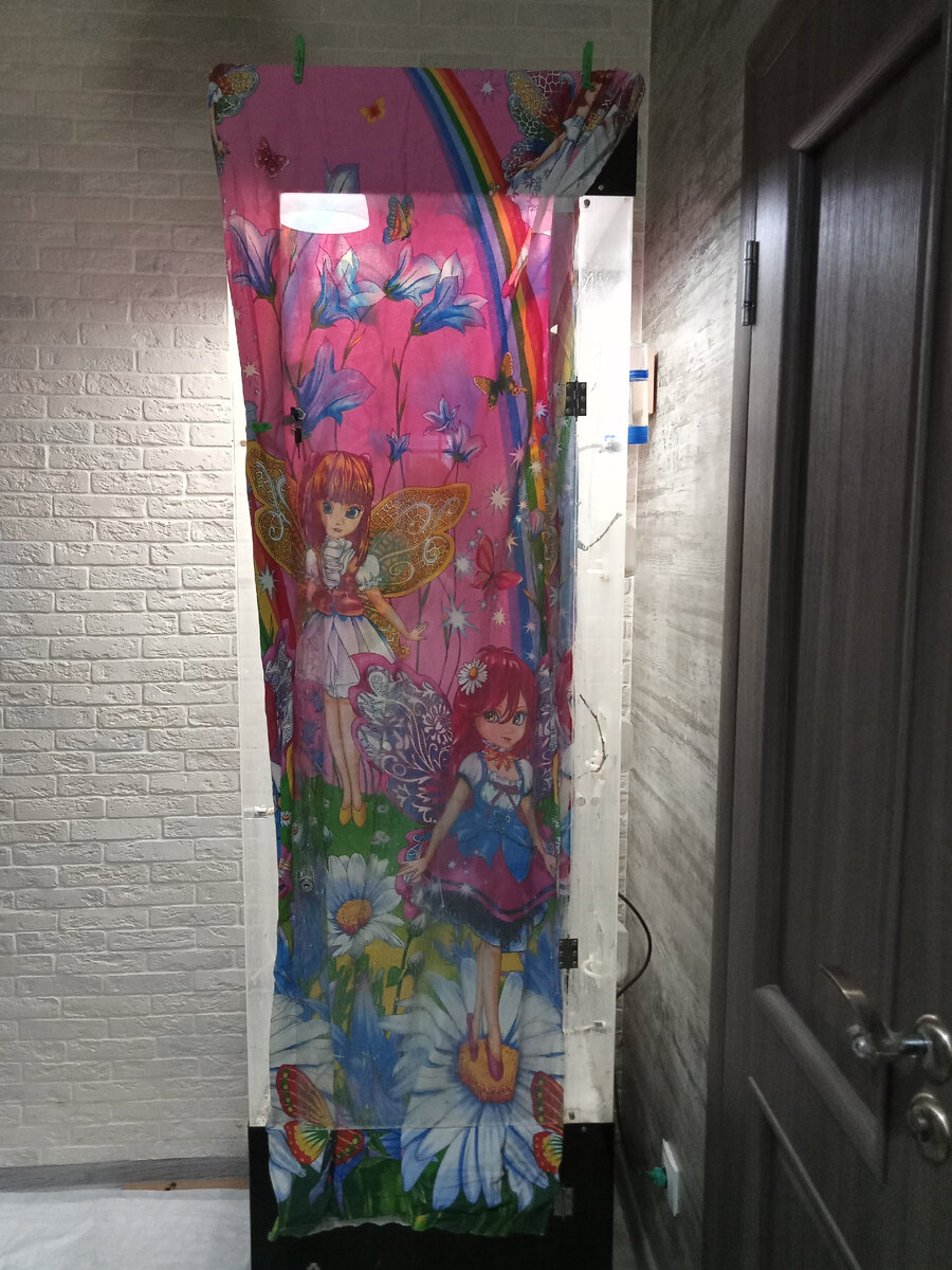 Простыня с феями закреплена прищепками на витрине