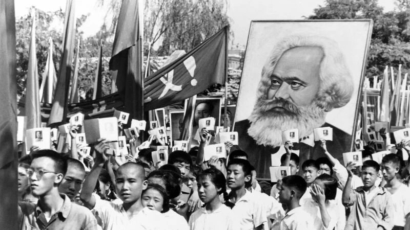 Молодые люди на митинге размахивают «Маленькой красной книгой» Мао и несут портрет Карла Маркса, 14 сентября 1966 года. «Культурная революция» положила начало десятилетию насилия и беспорядков, направленных на достижение коммунистических целей и внедрение радикального эгалитаризма. (AP Photo)