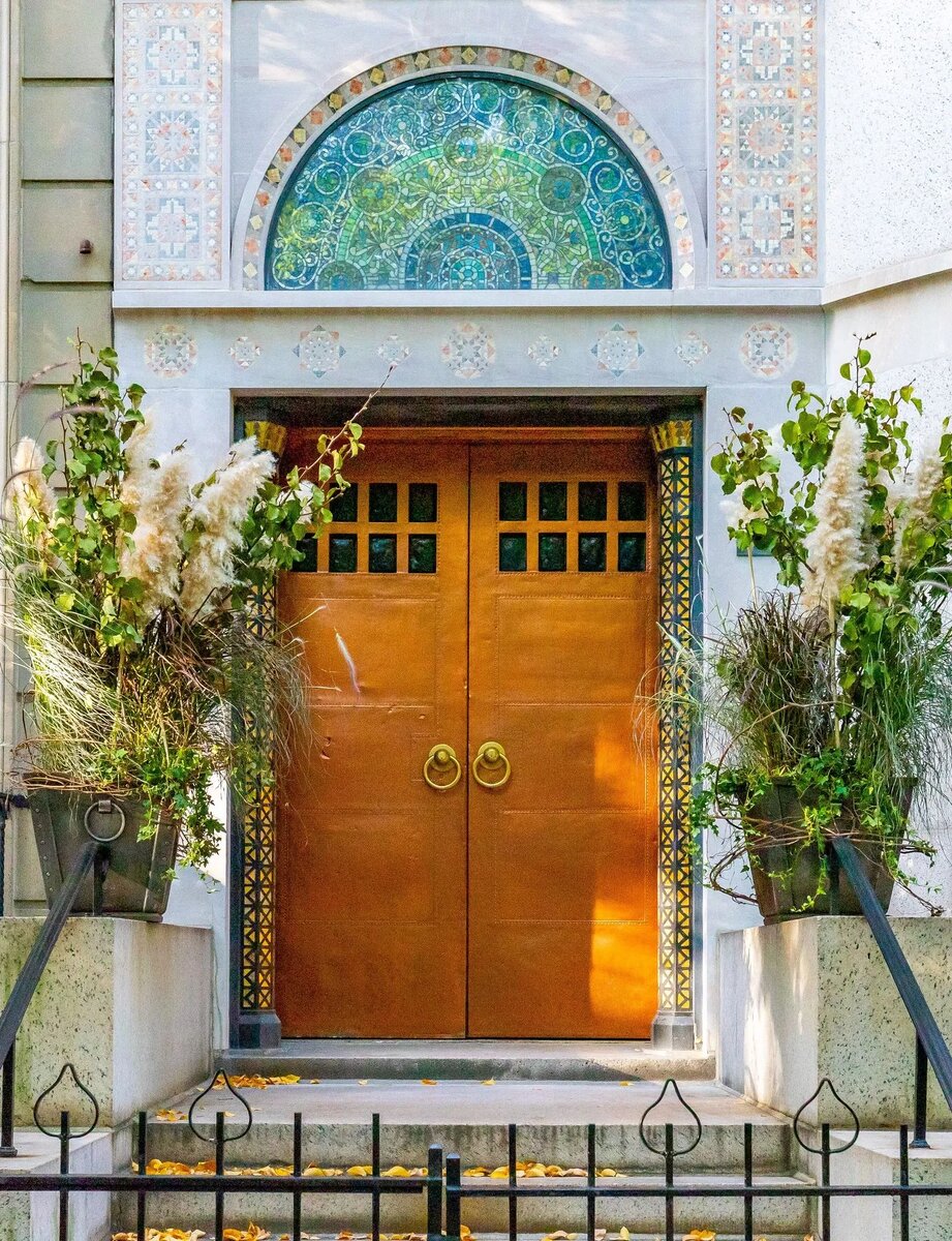 Фасад облицован светлым полированным известняком и декорирован яркими мозаичными панелями. Над входной дверью, сверкающей листовой медью, встроен витражный десюдепорт в виде полумесяца.