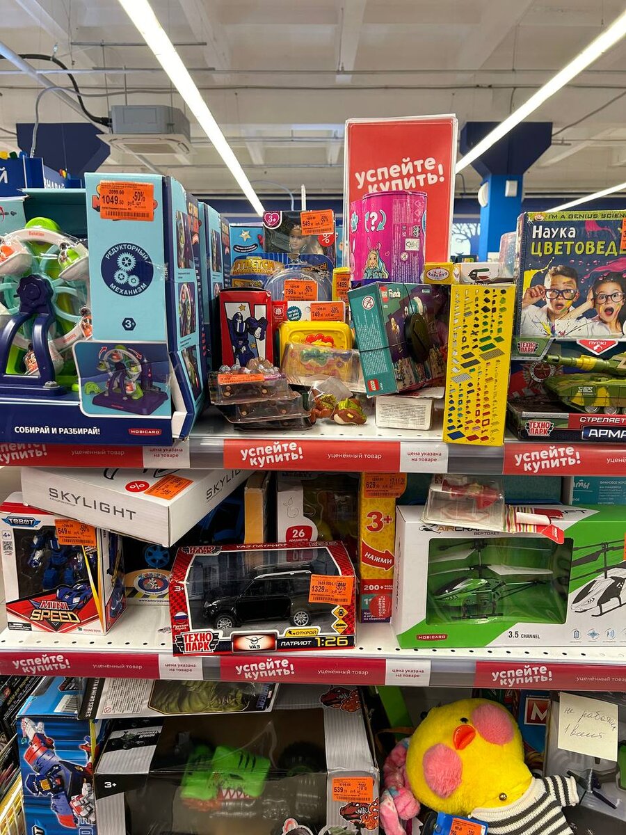 На этой полке лежат уцененные игрушки. На каждом ценнике указана причина уценки