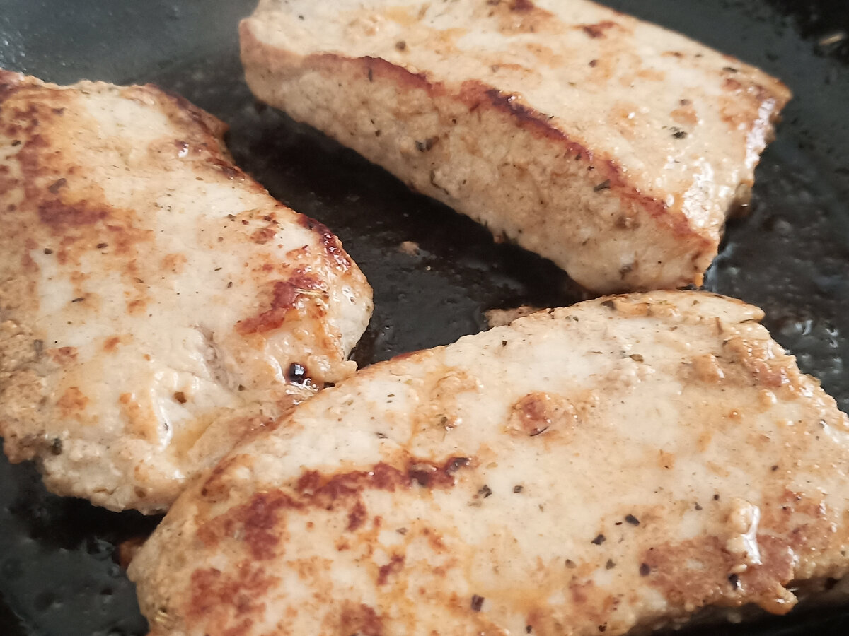 Жарятся стейки из свинины.