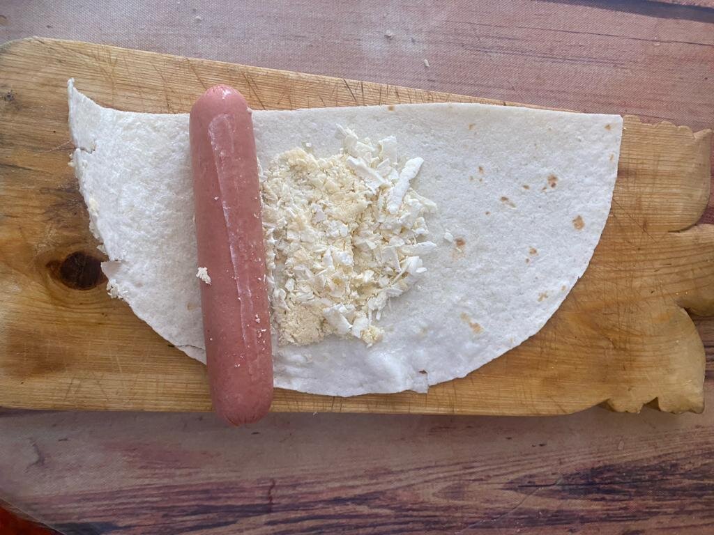 Укладываем сосиску и добавляем натертый сыр, кому сколько нравится.