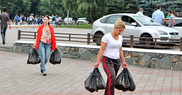 Женщина с тяжелыми сумками. Девушка несет сумку. Женщина с сумками из магазина. Женщина тащит пакеты.