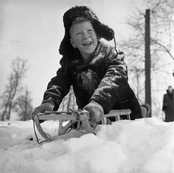 © Sputnik / В. Володкин Мальчик катается на санках. Декабрь 1960 года.