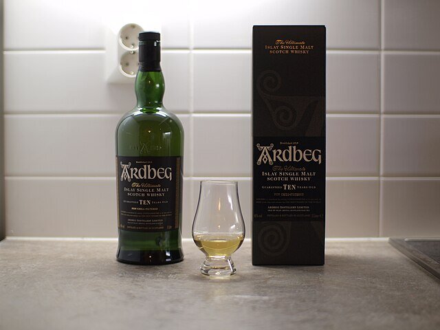 JIP. Бутылка односолодового шотландского виски Ardbeg 10-летней выдержки вместе с небольшим количеством виски, налитым в специально разработанный стакан для виски.