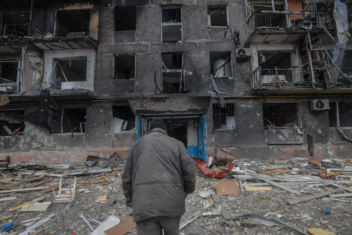 Житель идет к подъезду разрушенного дома на окраине Мариуполя // Sputnik / Алексей Куденко