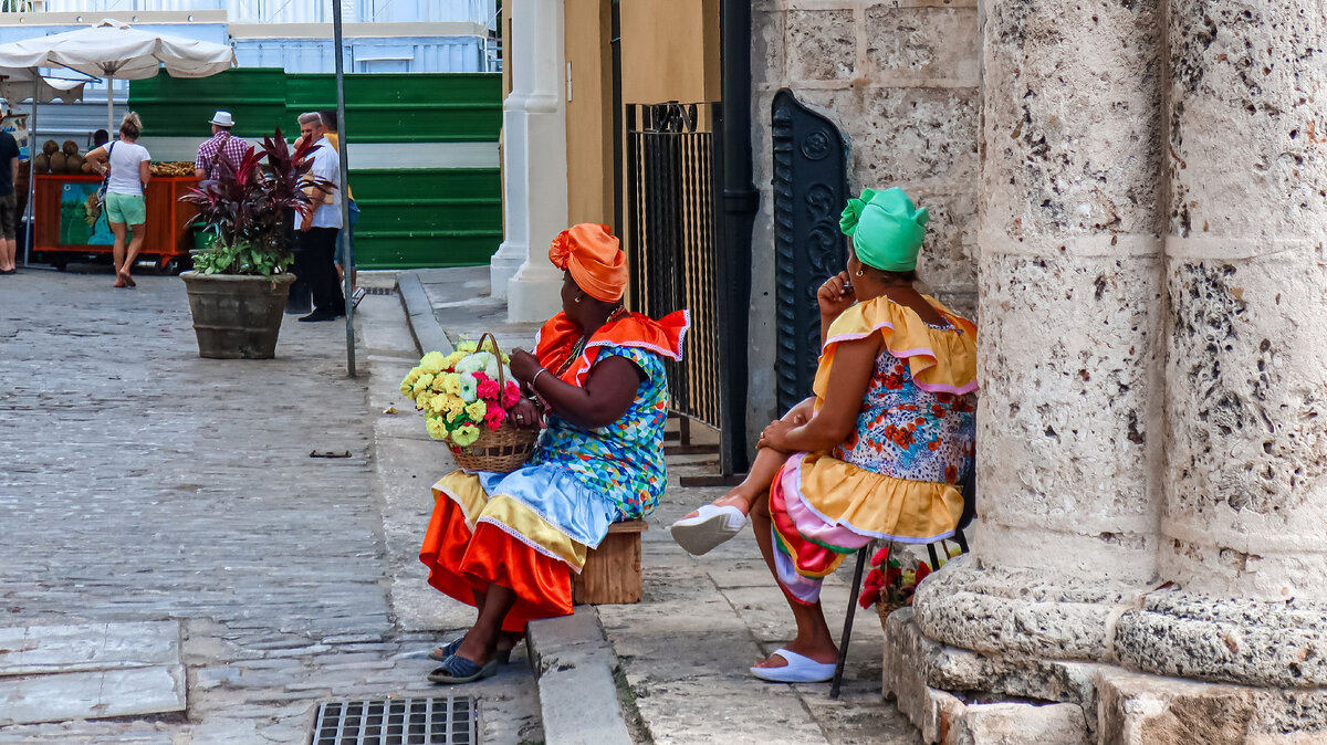 Нарядные кубинки в ярких платьях продают цветы.