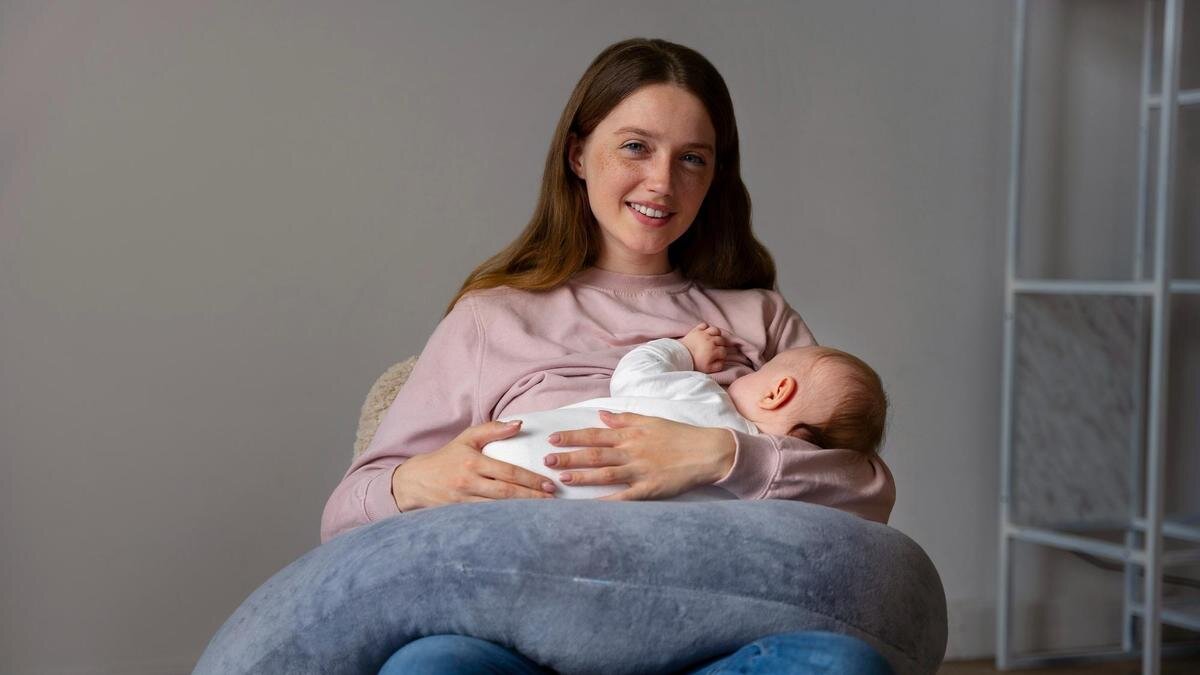    Женщина кормит ребенка грудью:Freepik