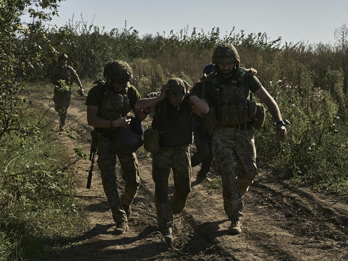    Украинские военнослужащие эвакуируют раненого солдата на передовой в Донецкой области© AP Photo / LIBKOS