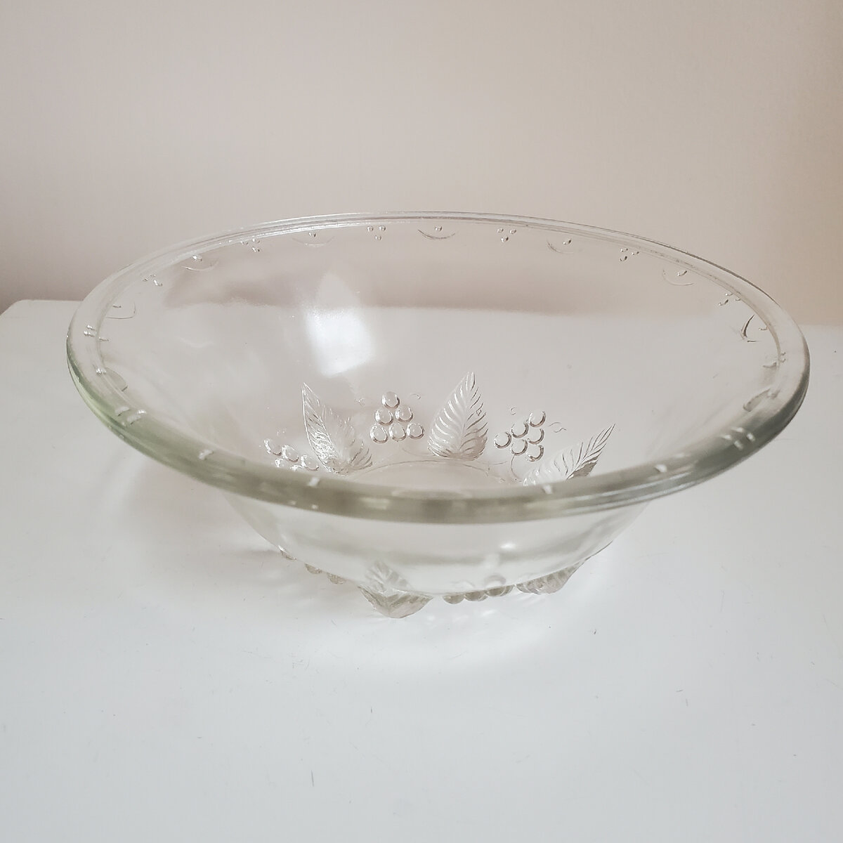 Старинный салатник из стекла имеет красивую форму. На стекле алмазная гравировка в виде виноградной лозы по нижней окружности.