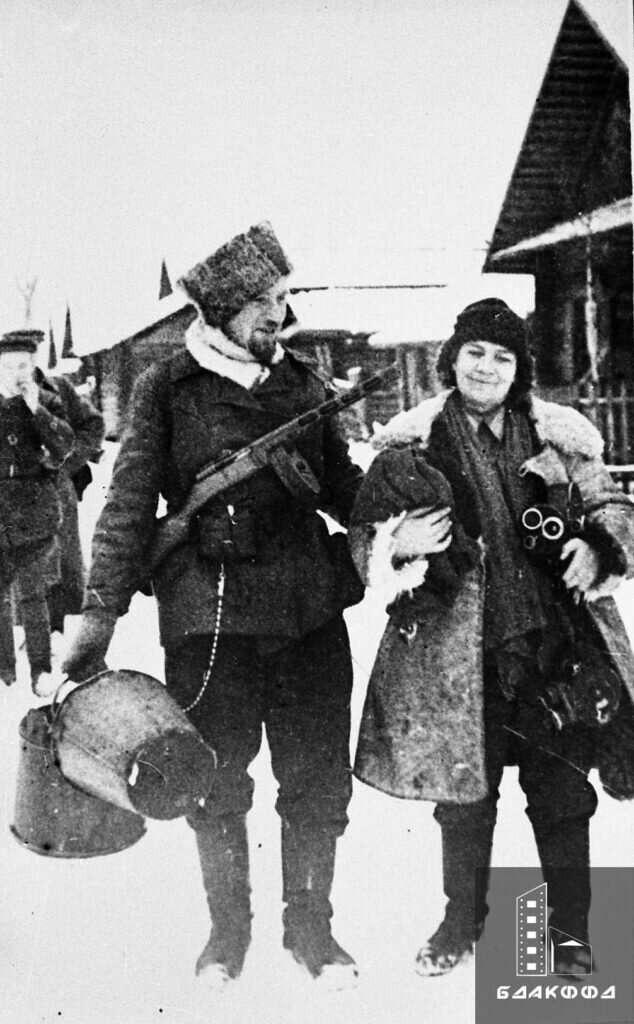 Командир конного взвода партизанской бригады «Железняк» А. Красулин и кинооператор М.И. Сухова, прибывшая на съемку фильма «Народные мстители», март 1943 г.
