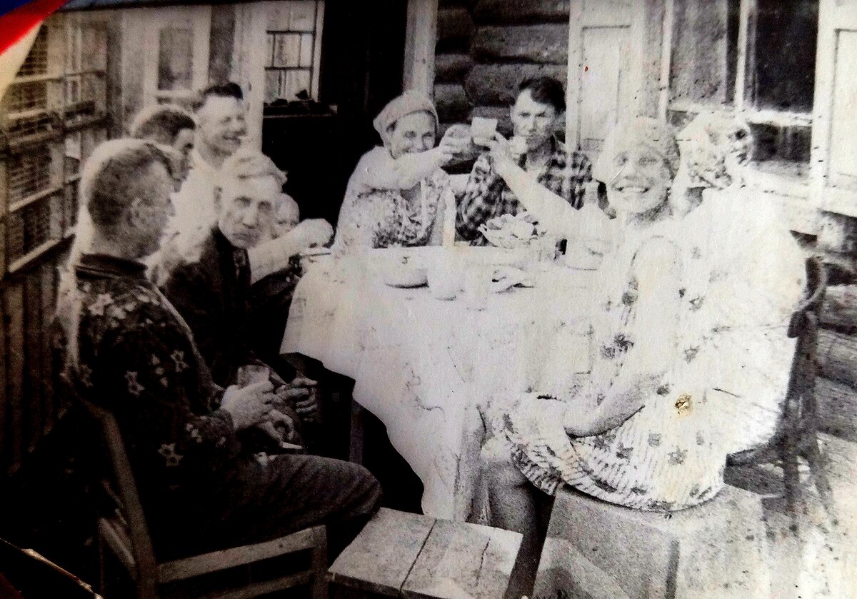 Тётя Зина смотрит на камеру,чёкается с моей мамой. дядя Вася выглядывает из-за мужчины. С папироской мой папа. А возле папы мои глазки.