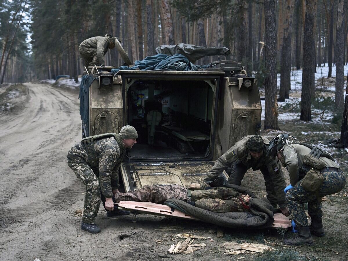    Украинские военные эвакуируют раненого© AP Photo / LIBKOS