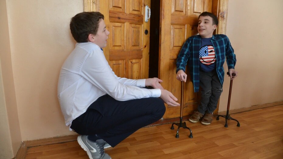 Дети одеваются на прогулку в детском саду. Одеть ребенка. Мама одевает малыша. Забота о младших. Ребенок одевается.