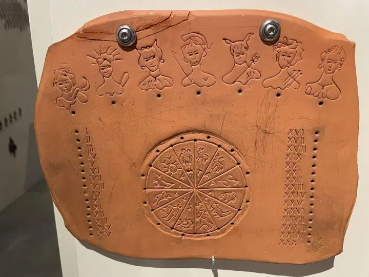 Позднеримский каменный календарь (парапегма). 3 - 4 вв. н. э. Наверху изображены боги, управляющие днями недели. Посреди изображён зодиак, а слева и справа — числа месяца.