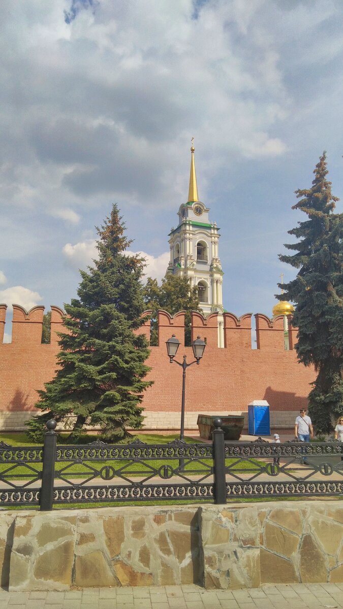 За стеной видна красивая колокольня, по периметру кремля благоустроенный сквер