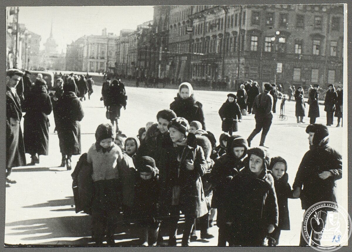 Дети на улице Ленинграда во время блокады. Фотография кадра из фильма «Ленинград в борьбе». [Весна 1942 г.] РГАЛИ. Ф. 2989. Оп. 1. Ед. хр. 76. Л. 18. Фотокопия.
