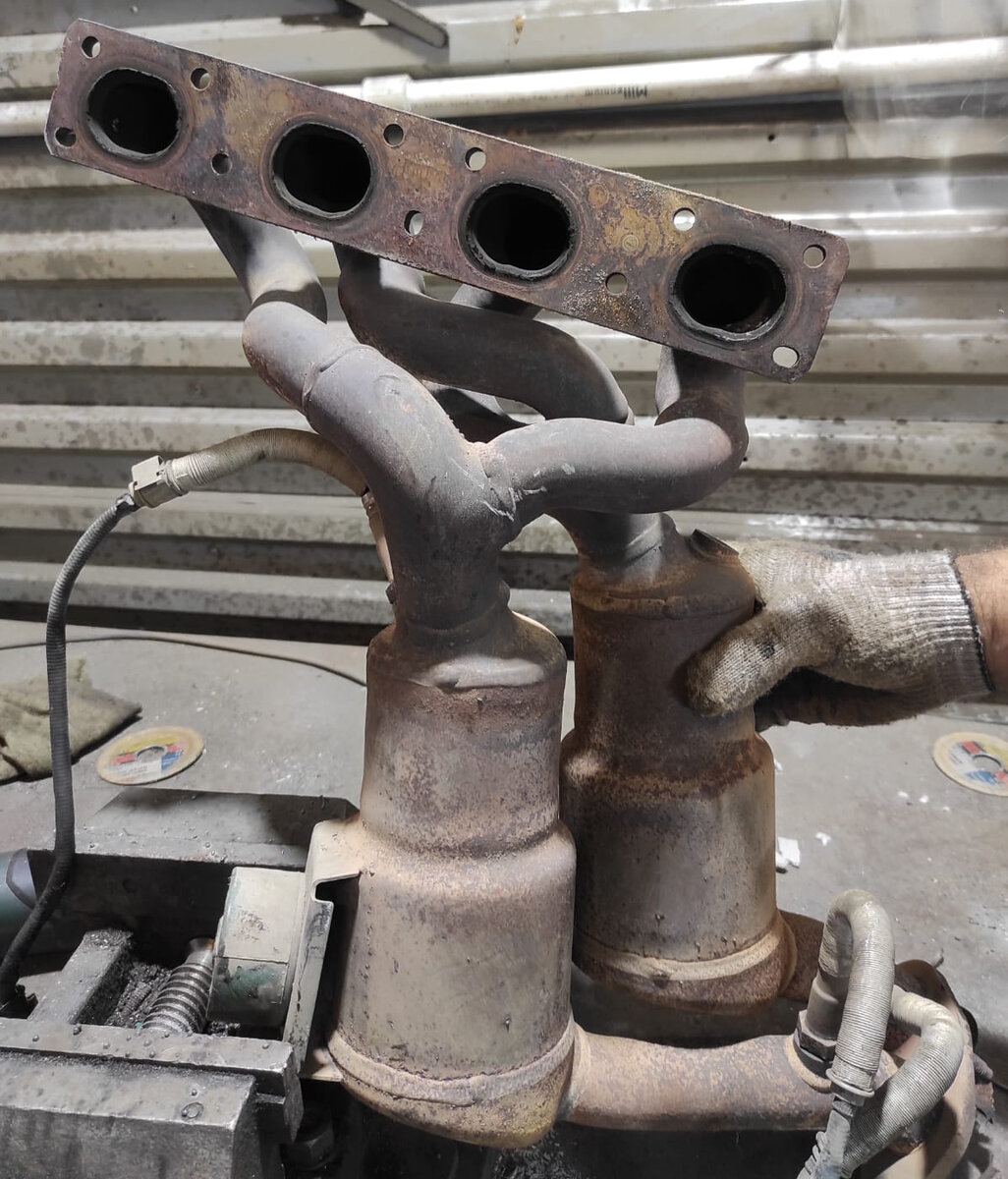 Вот так выглядит выпускной коллектор с двумя катализаторами в случае двигателя N46B20. Внутри каждого корпуса стоят две круглые кассеты. Сначала с меньшим диаметром, а следом крупнее. На фото заметно, что диаметр каждого корпуса сначала и в конце разный.