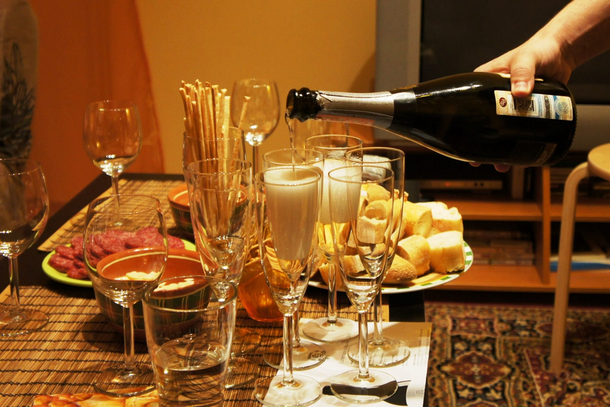 Этикет шампанского. Накрытый стол с вином. Празднично накрытый стол с фужерами вина. Праздничный стол с алкоголем. Бокал с шампанским на столе.