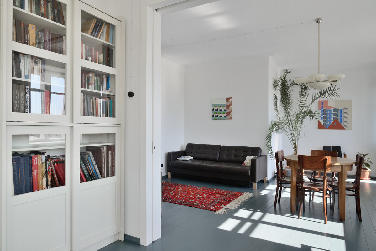 Фрагмент библиотеки и гостиная в квартире в Москве. Дизайн Марии Пилипенко и Николая Лызлова. Английское кресло 1950-х годов, автор картин – Александр Зайцев. Реставрацией окон и дверей занимался Александр Серебряков. Стулья и стол датируются 20–30-ми годами.