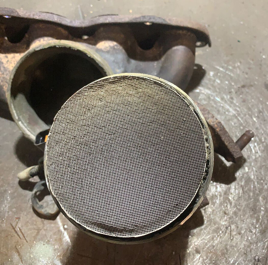 Режем корпус по сварному шву и видим, что внутри сотовая структура. Виден верхний каталитический элемент, под которым вплотную находится еще один.