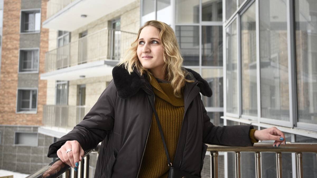    Жительница одной из расселяемых пятиэтажек в районе Чертаново Южное Иветта Шереметьева вышла на балкон своей квартиры, предоставленной ей по программе реновации в новостройке на Варшавском шоссе / Фото: Пелагия Замятина / Вечерняя Москва