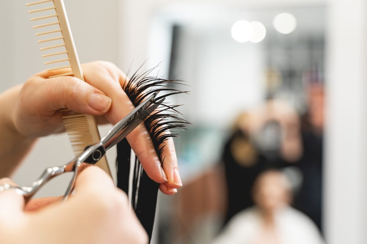    Refresh young haircut. Silhouette of young brunette girl that looking at her reflection while doing new hairstyle