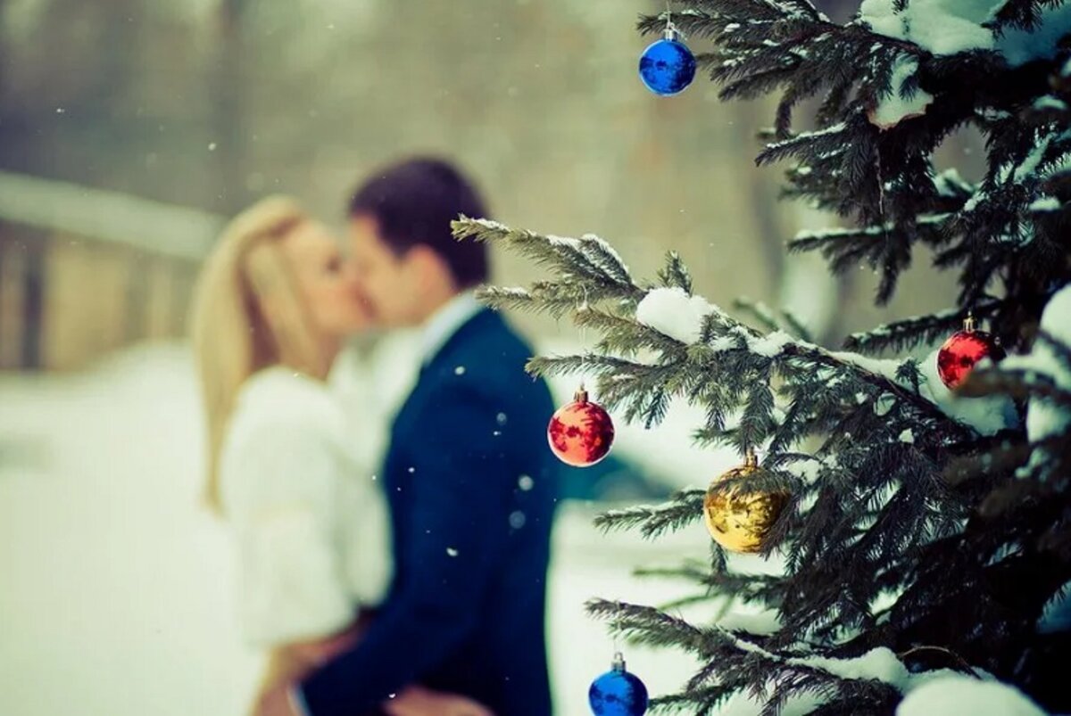 Новый год влюбленные. Новый год любовь. Парень с девушкой у елки. Поцелуй под елкой. Начинаем жить в новом году