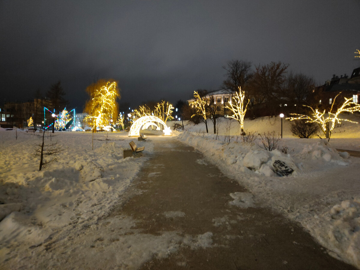 Все деревья украшены гирляндами, а дорожки яркими арками