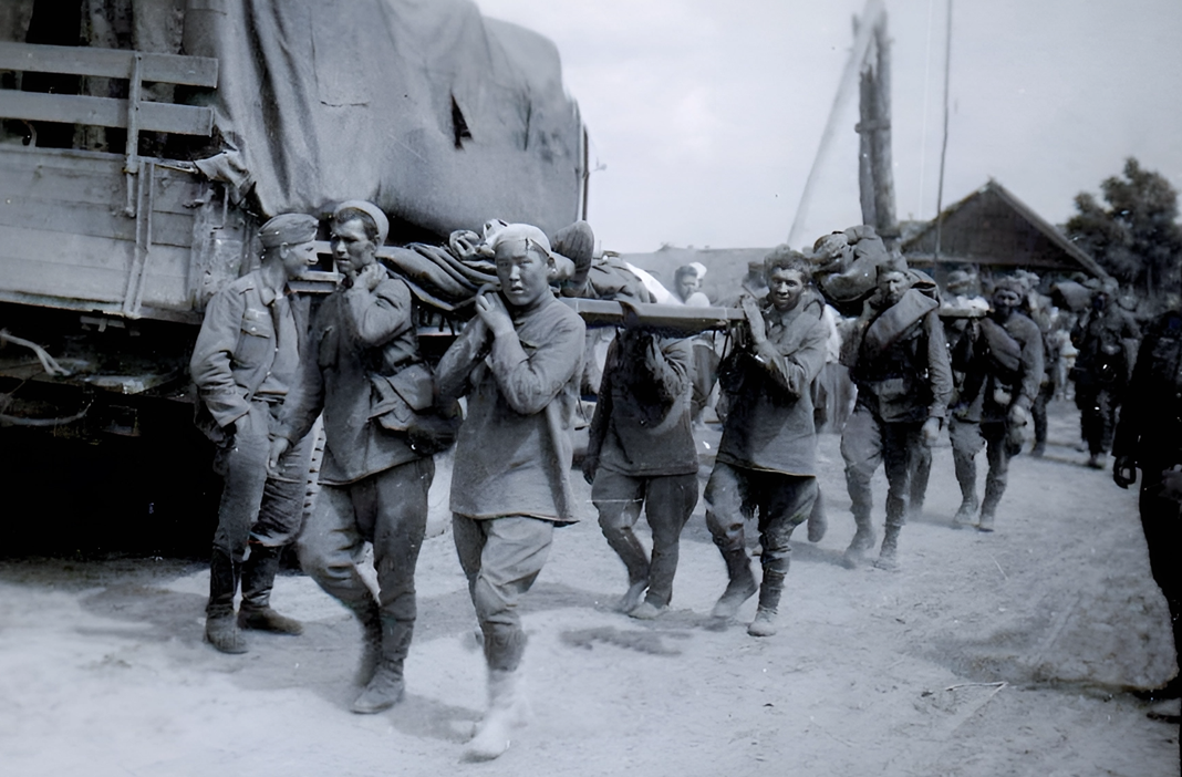 Советские военнопленные несут раненых товарищей, 1941 г.