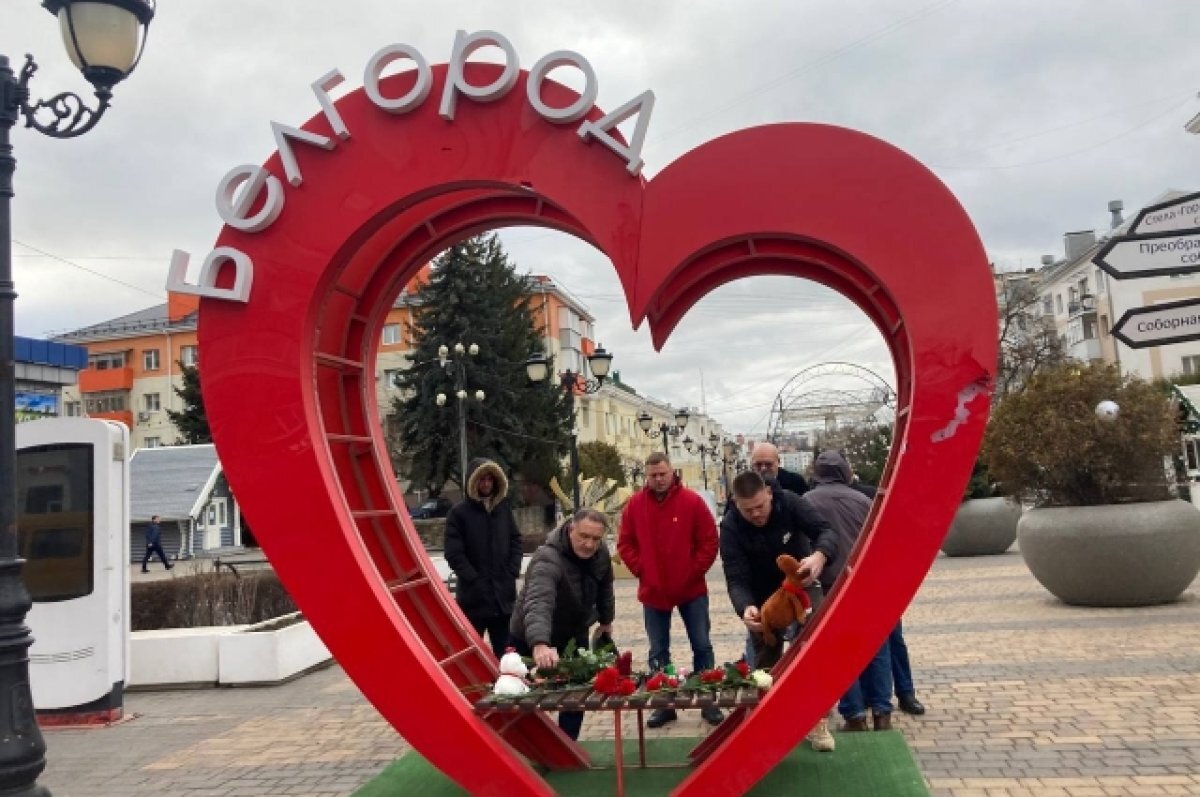    Жители несут цветы к стихийным мемориалам.