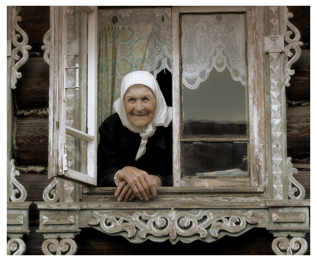 Дома старой женщины. Бабушка у окна. Старушка у окна. Бабушка в окошке. Старушка у окна в деревне.