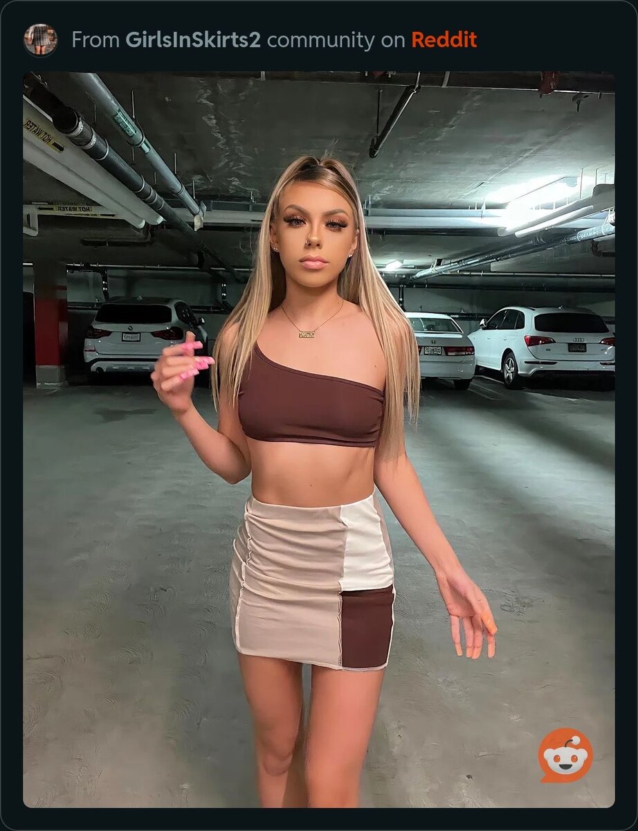 Стоит на парковке в мини юбке
