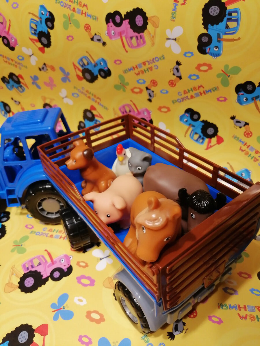 Игрушки животных в синем тракторе.