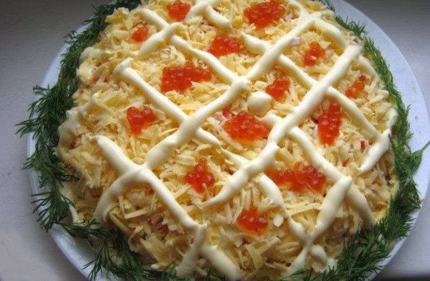 салат собран слоями-капуста пекинская,крабовое мясо,яйца,рыбка красная,сыр и сверху украшен икрой