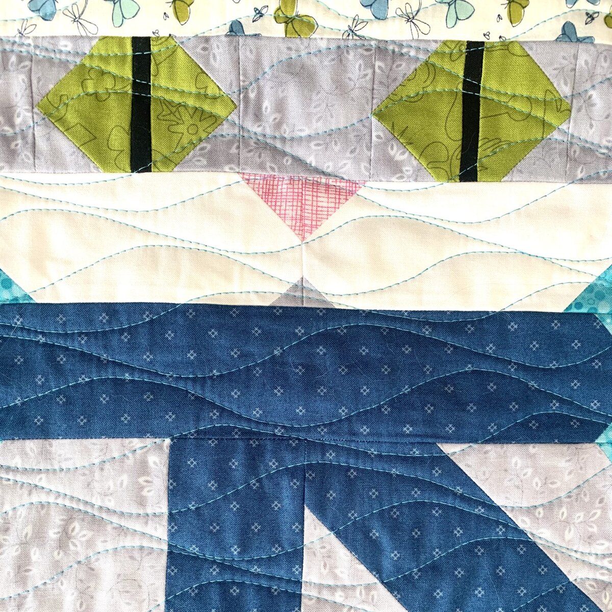 Стежка органическими волнистыми линиями от края до края на домашней машинке, используя синие нитки, как сверху, так и снизу.