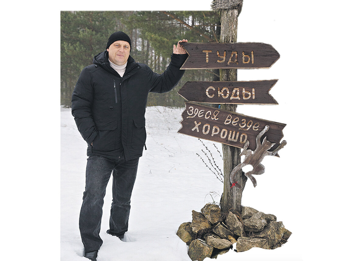 Александр Гревцев показывает журналистам смешные указатели, созданные местными умельцами